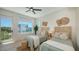Bright bedroom featuring two beds, a large window, and wicker decor at 8800 Midnight Pass Rd, Sarasota, FL 34242