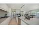 Stylish kitchen with stainless steel appliances, large center island, and light wood floors at 8800 Midnight Pass Rd, Sarasota, FL 34242