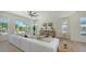 Spacious living area featuring a white corner sofa, natural wood accents, and large windows with pleasant outdoor views at 8800 Midnight Pass Rd, Sarasota, FL 34242