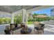 View of the covered patio with pillars, contemporary patio furniture and a beautiful green space in the backyard at 8800 Midnight Pass Rd, Sarasota, FL 34242