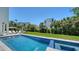 View of the backyard swimming pool and spa with outdoor kitchen and dining area surrounded by lush landscaping at 8800 Midnight Pass Rd, Sarasota, FL 34242