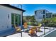 View of the rooftop deck with outdoor seating, metal railing, and lush tropical landscaping nearby at 8800 Midnight Pass Rd, Sarasota, FL 34242