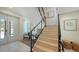 Bright entryway with modern staircase featuring light wood steps, black metal railings, and stylish decor at 8800 Midnight Pass Rd, Sarasota, FL 34242