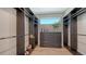 Spacious walk-in closet with custom shelving, drawers, and a window for natural light at 8800 Midnight Pass Rd, Sarasota, FL 34242