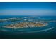 Aerial view of the tropical land mass with houses and roads surrounded by deep blue ocean water at 89 Avenida Messina, Sarasota, FL 34242