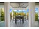Covered balcony perfect for dining while enjoying the view of tropical landscaping and blue skies at 89 Avenida Messina, Sarasota, FL 34242