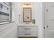 Stylish powder room with a marble countertop, modern fixtures, and a well-lit mirror, creating a clean and elegant space at 89 Avenida Messina, Sarasota, FL 34242