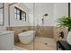 Bright bathroom with a standalone tub, walk-in shower, wood accents and tile floors at 89 Avenida Messina, Sarasota, FL 34242