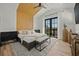 Modern bedroom with wood beam headboard, natural light from French doors and light wood floors at 89 Avenida Messina, Sarasota, FL 34242