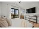 Modern bedroom with natural light from French doors, TV, wood floors and decorative vases at 89 Avenida Messina, Sarasota, FL 34242