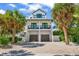 Beautiful beach home featuring a two-car garage and multiple levels of covered balconies at 89 Avenida Messina, Sarasota, FL 34242