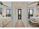 Bright hallway featuring natural light, wood floors and access to two bedrooms with floor to ceiling windows at 89 Avenida Messina, Sarasota, FL 34242