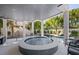 Outdoor patio featuring a covered spa, swimming pool, lush landscaping, and comfortable seating at 89 Avenida Messina, Sarasota, FL 34242