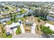 Aerial view showcases a home with canal access, mature trees, and landscaped yard at 891 Palmetto Ne Dr, Port Charlotte, FL 33952