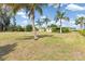 Spacious backyard surrounded by tropical palm trees with a clear view of the home at 891 Palmetto Ne Dr, Port Charlotte, FL 33952