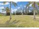 Lush green backyard with mature trees and plenty of space for outdoor activities at 891 Palmetto Ne Dr, Port Charlotte, FL 33952