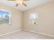 Bright bedroom featuring tile floors, a ceiling fan, and natural light from two windows at 891 Palmetto Ne Dr, Port Charlotte, FL 33952