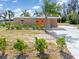 Charming single-story brick home featuring a well-maintained lawn and lush greenery around the perimeter at 891 Palmetto Ne Dr, Port Charlotte, FL 33952
