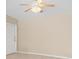 Neutrally painted living room with a ceiling fan and a door at 891 Palmetto Ne Dr, Port Charlotte, FL 33952