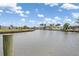 Scenic waterfront view of a canal lined with lush greenery and residential homes under a clear blue sky at 891 Palmetto Ne Dr, Port Charlotte, FL 33952