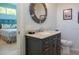 Modern bathroom showcasing a stylish vanity, a round mirror, and an open doorway to the bedroom at 91 Avenida Veneccia, Sarasota, FL 34242