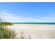 Expansive sandy beach with clear turquoise waters under a bright blue sky, perfect for relaxation at 91 Avenida Veneccia, Sarasota, FL 34242