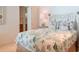 Charming bedroom showcasing a patterned bedspread, decorative pillows, and a view into the ensuite bathroom at 91 Avenida Veneccia, Sarasota, FL 34242