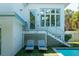 Exterior of home with stairs leading to upper level and outdoor lounge area with pool view at 91 Avenida Veneccia, Sarasota, FL 34242