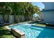 Inviting backyard pool with a waterfall feature, surrounded by lush greenery and an umbrella table set at 91 Avenida Veneccia, Sarasota, FL 34242
