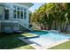 Beautiful pool area with waterfall feature, lush greenery, and comfortable lounge chairs on the lawn at 91 Avenida Veneccia, Sarasota, FL 34242
