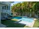 Inviting backyard pool with a waterfall feature, surrounded by lush greenery and lounge chairs at 91 Avenida Veneccia, Sarasota, FL 34242