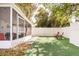 View of the fenced backyard with a screened in patio and chairs at 1018 Charlotte Ave, Sarasota, FL 34237