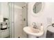 Cozy bathroom showcasing a glass enclosed shower and round mirror above a pedestal sink at 1018 Charlotte Ave, Sarasota, FL 34237