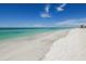 Expansive view of a serene beach with crystal clear water and white sand under a beautiful blue sky at 1018 Charlotte Ave, Sarasota, FL 34237