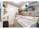 Functional laundry room featuring a washer, dryer, shelving, and a door to the exterior at 1018 Charlotte Ave, Sarasota, FL 34237