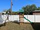 Backyard features a wooden playset with swings, slide, and climbing area, all enclosed by a secure white fence at 1018 Charlotte Ave, Sarasota, FL 34237