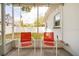 Screened patio with a view of the fenced backyard and a pair of bright orange chairs at 1018 Charlotte Ave, Sarasota, FL 34237