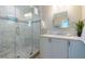 Bright bathroom featuring a marble tiled shower with glass doors and a modern vanity with white cabinets at 113 8Th S St, Bradenton Beach, FL 34217