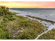 Picturesque coastal view of a tranquil beach meeting the ocean under a colorful sunset sky, ideal for serene escapes at 113 8Th S St, Bradenton Beach, FL 34217