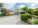 Charming coastal home with a three-story deck, vibrant plants, and a pristine driveway at 113 8Th S St, Bradenton Beach, FL 34217