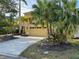 Exterior shot of this home featuring mature palms and landscaping and a two car garage at 11516 Sweetflag Dr, Lakewood Ranch, FL 34202
