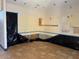Room under repair, featuring tile flooring, bare drywall, and an arched doorway at 11516 Sweetflag Dr, Lakewood Ranch, FL 34202