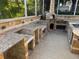 Outdoor kitchen with granite countertops, a brick oven, and a brick-paved floor at 11516 Sweetflag Dr, Lakewood Ranch, FL 34202