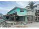 Hurricane damage to a blue, two-story home with missing walls and debris at 1190 Shore View Dr # C, Englewood, FL 34223