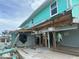 Exterior view of damaged turquoise home at 1190 Shore View Dr # C, Englewood, FL 34223