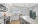 Modern kitchen with white cabinetry, stainless steel appliances, and a window with natural light at 12415 Dockside Ter, Cortez, FL 34215