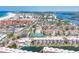 Aerial view of a coastal condo community with tennis courts, a pool, a boat dock, and beach access at 1250 N Portofino Dr # 304, Sarasota, FL 34242