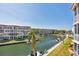 Aerial view of a waterfront condo community with boat docks and manicured lawns under a clear blue sky at 1250 N Portofino Dr # 304, Sarasota, FL 34242