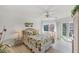 Bright bedroom featuring a floral comforter, woven headboard, and sliding doors to a private balcony at 1250 N Portofino Dr # 304, Sarasota, FL 34242
