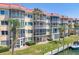 Multi-story condo with screened patios, lush landscaping, red tile roof, and waterfront access with dock at 1250 N Portofino Dr # 304, Sarasota, FL 34242